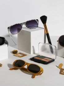 Sunglasses, jewellery and accessories laid out on a table.