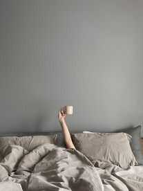 Person in bed with coffee cup