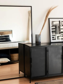 A black sideboard and standing mirror in a modern entrance room from Studio Delta.