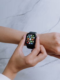 A women using her Apple watch from SSS Cellular. Her hands are over a marble table.